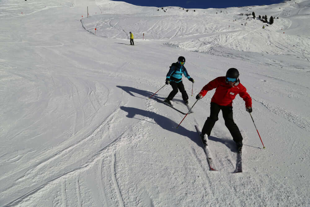 Learn to ski. Adult group ski course plow turning.