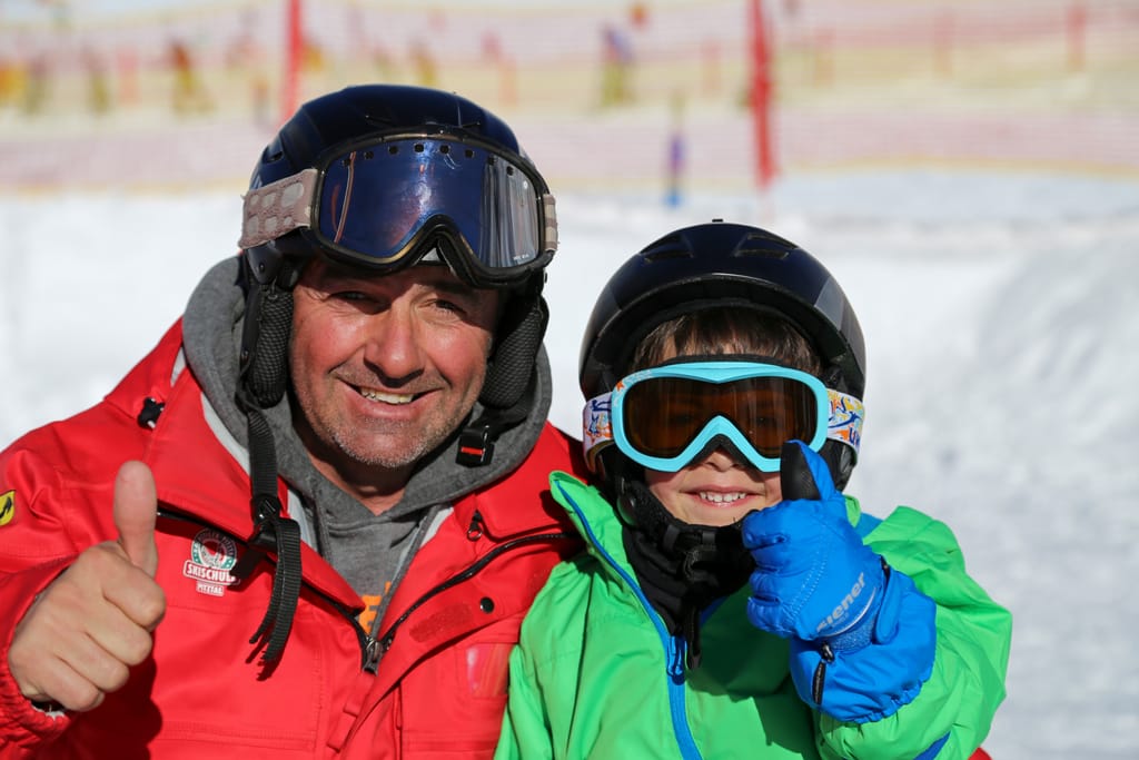 wie wird man Skilehrer. Skilehrer mit zufrieden Teilnehmer. 